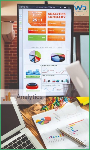 Tableau de bord Analytics affichant des graphiques de performance et des KPIs business sur un écran vertical et des rapports papier.